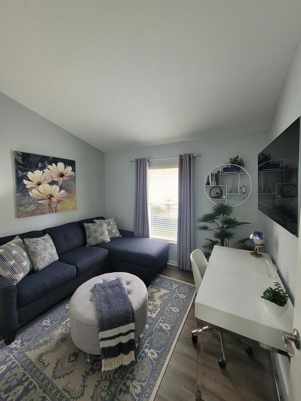 living room featuring lofted ceiling and dark hardwood / wood-style flooring