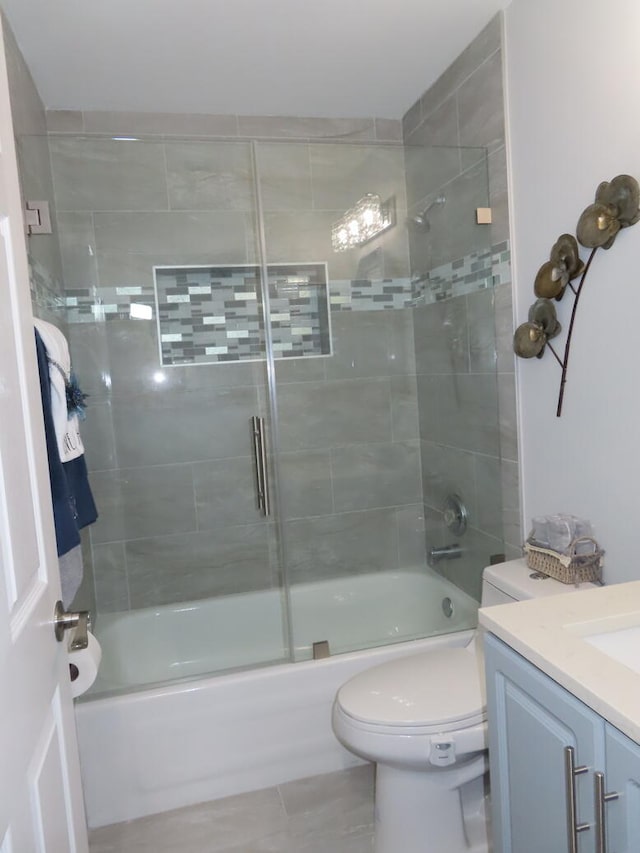 full bathroom featuring combined bath / shower with glass door, vanity, and toilet