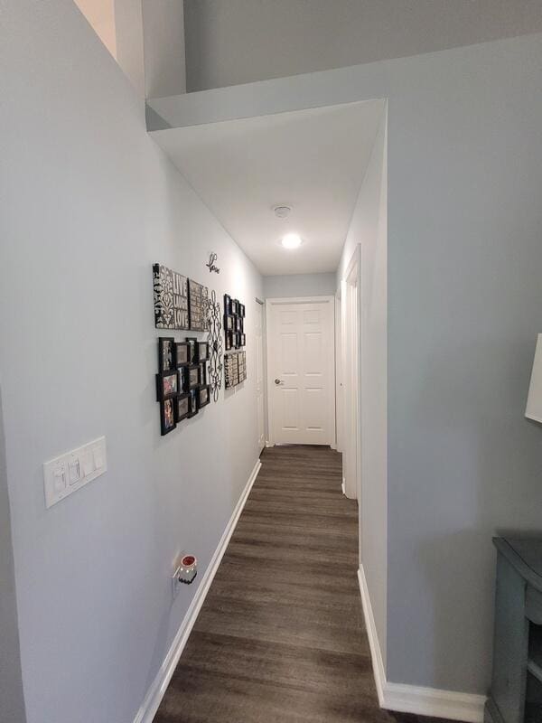 corridor with dark hardwood / wood-style flooring