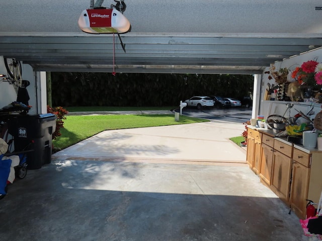 garage with a garage door opener, a lawn, and a carport