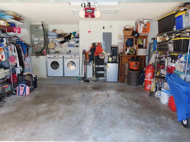 garage with a garage door opener, electric panel, and independent washer and dryer