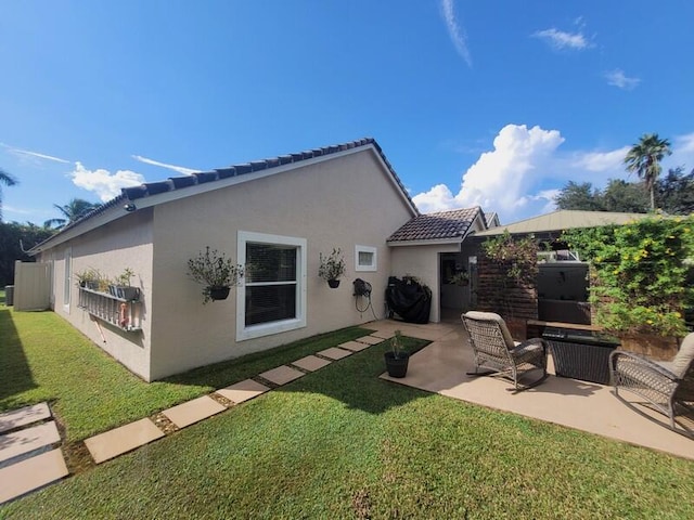 rear view of property with a lawn and a patio