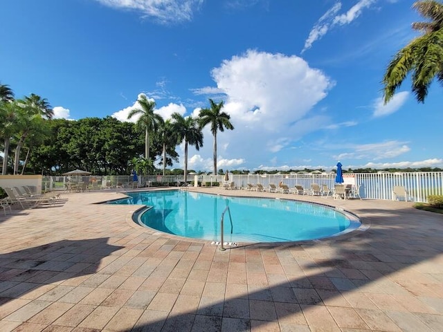 view of swimming pool with a patio and a water view