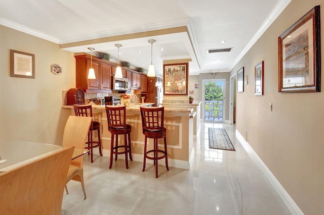 kitchen with pendant lighting, kitchen peninsula, crown molding, and appliances with stainless steel finishes