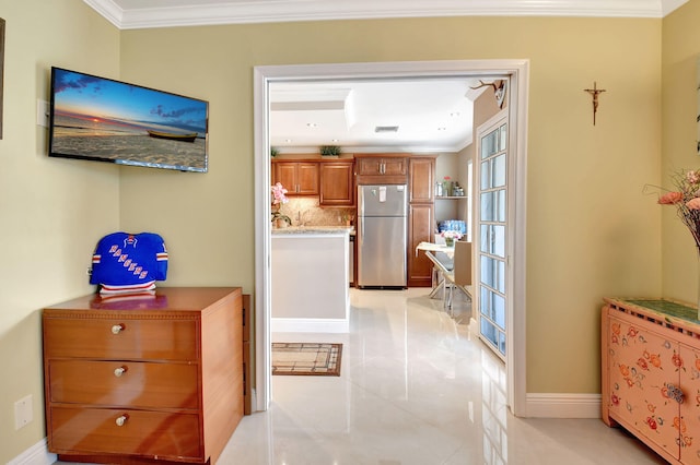 hall with light tile patterned floors and crown molding