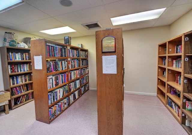 2721 SW 15th St Unit 203, Delray Beach, FL 33445 - sitting room with bookshelves, a paneled ceiling, and carpet