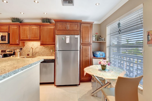 kitchen featuring crown molding, sink, decorative backsplash, light stone counters, and stainless steel appliances