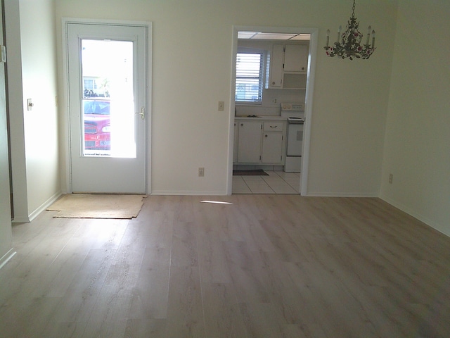 interior space featuring an inviting chandelier and light hardwood / wood-style floors