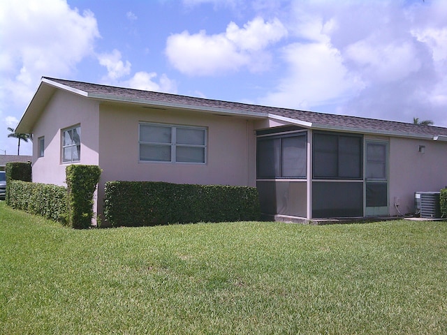 back of house with a lawn and central AC