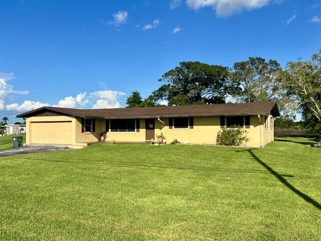 single story home with a front lawn and a garage