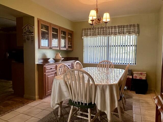 dining space featuring an inviting chandelier and light tile patterned floors