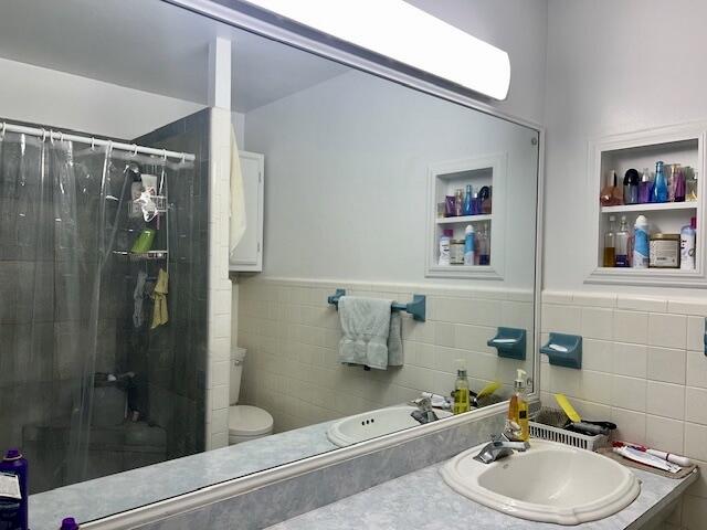 bathroom featuring walk in shower, vanity, and toilet