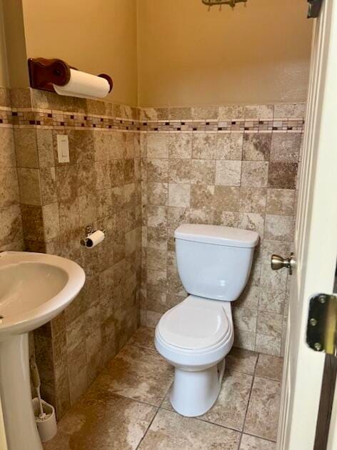 bathroom with tile walls and toilet