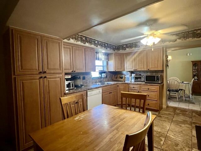 kitchen with decorative backsplash, dishwasher, ceiling fan, and sink