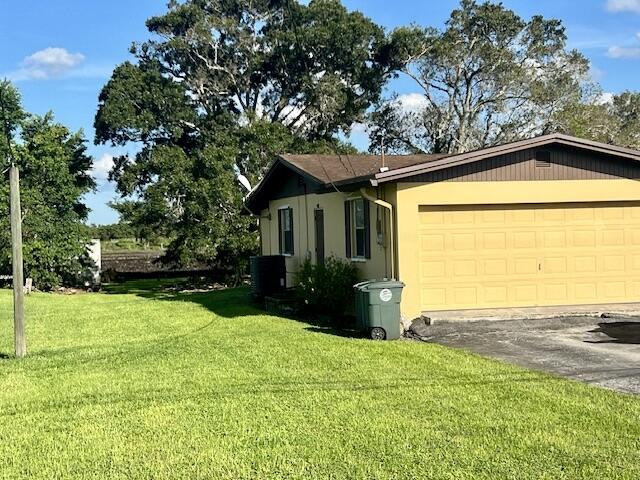 view of property exterior featuring a garage and a lawn