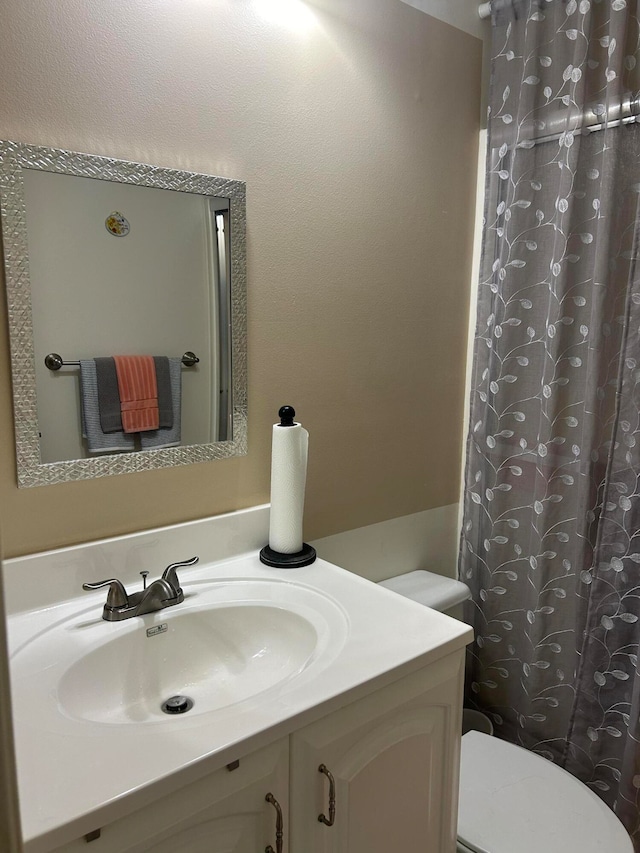 bathroom with toilet, a shower with curtain, and vanity