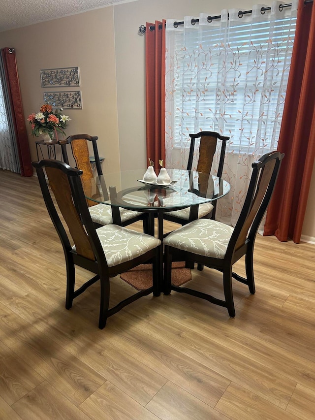 dining area featuring a textured ceiling and light wood-type flooring