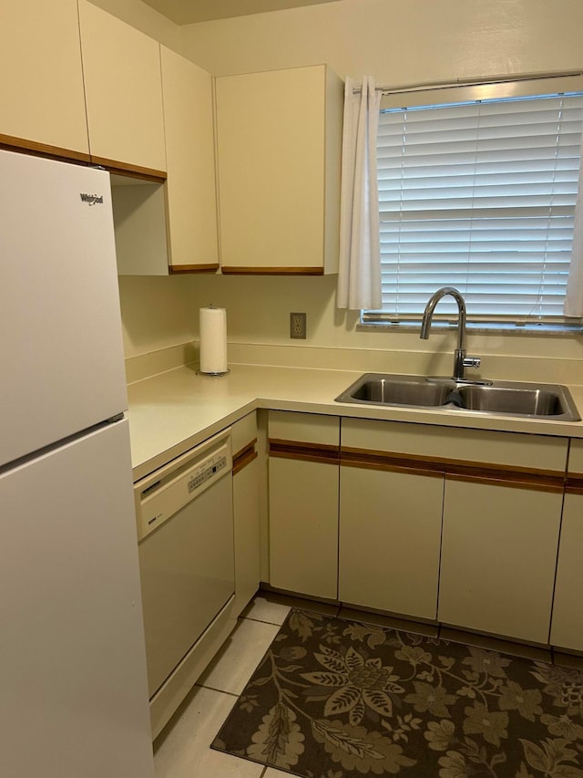 kitchen featuring sink, light tile patterned floors, and white appliances