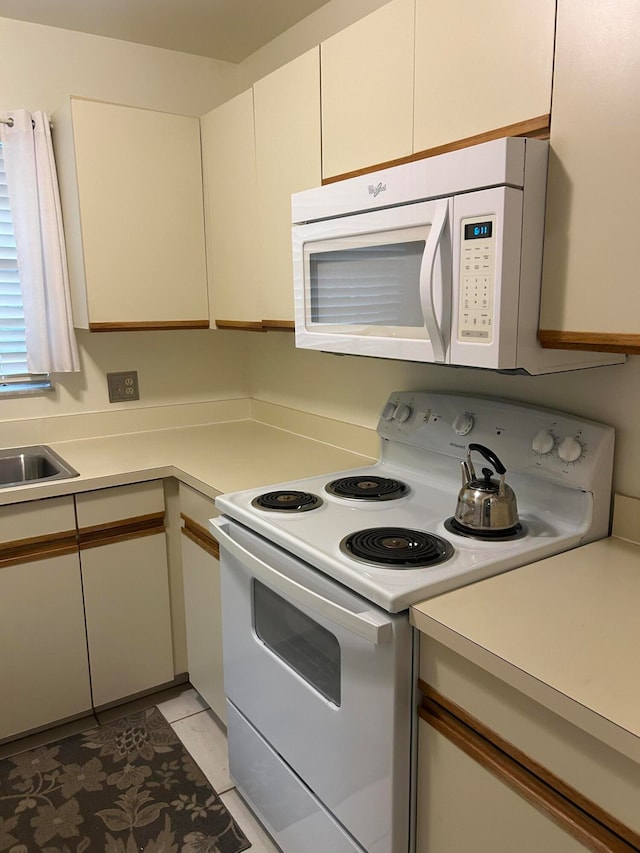 kitchen featuring sink, white appliances, and light tile patterned floors