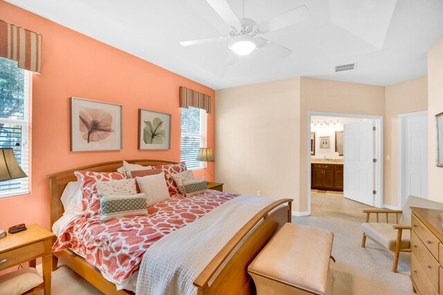 bedroom with connected bathroom, ceiling fan, and light colored carpet