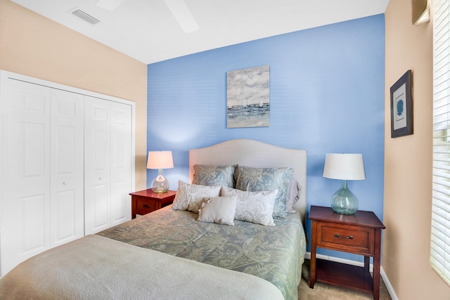 carpeted bedroom with ceiling fan and a closet