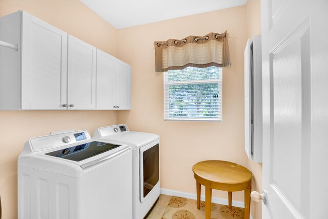 washroom with washer and clothes dryer, light tile patterned flooring, and cabinets