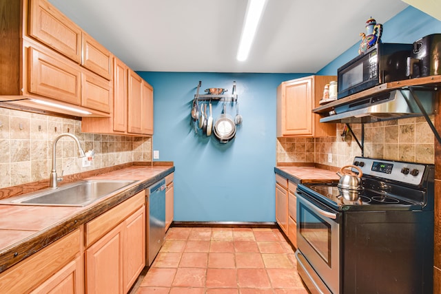 kitchen featuring stainless steel appliances, light brown cabinetry, tasteful backsplash, and sink