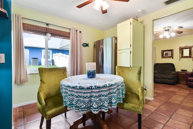 dining space with ceiling fan, tile patterned floors, and a textured ceiling