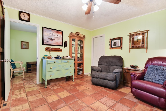 living area featuring ornamental molding, ceiling fan, and a textured ceiling