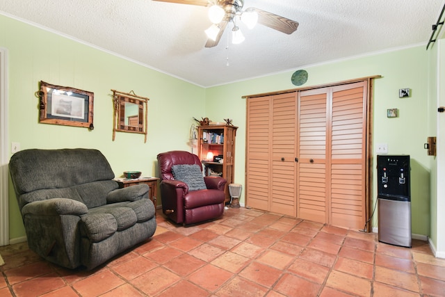 living area with a textured ceiling, crown molding, and ceiling fan