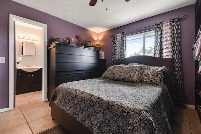 tiled bedroom with ceiling fan, ensuite bathroom, and a textured ceiling