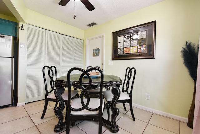 tiled dining area featuring ceiling fan and a textured ceiling