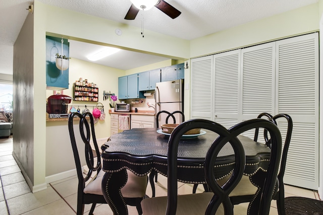 dining area with a textured ceiling, sink, light tile patterned floors, and ceiling fan