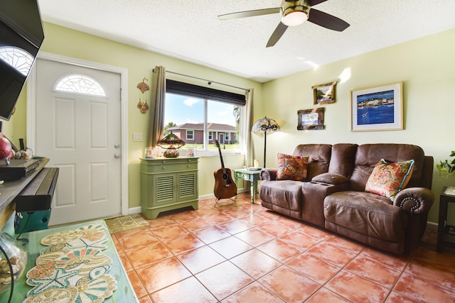 living room featuring a textured ceiling, light tile patterned floors, ceiling fan, and plenty of natural light