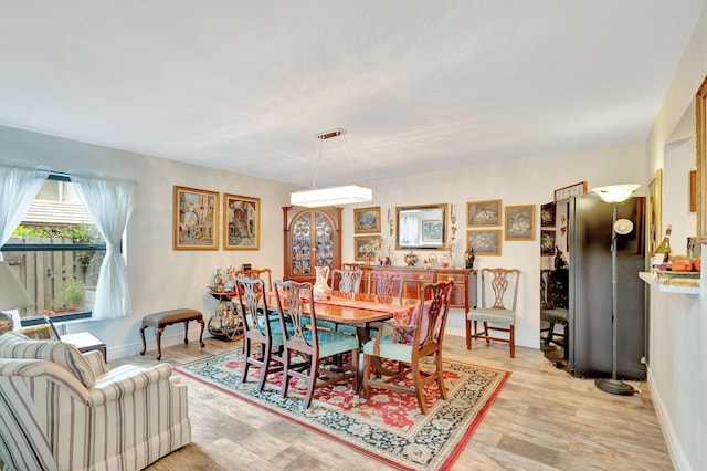 dining space with light hardwood / wood-style flooring and a wall unit AC