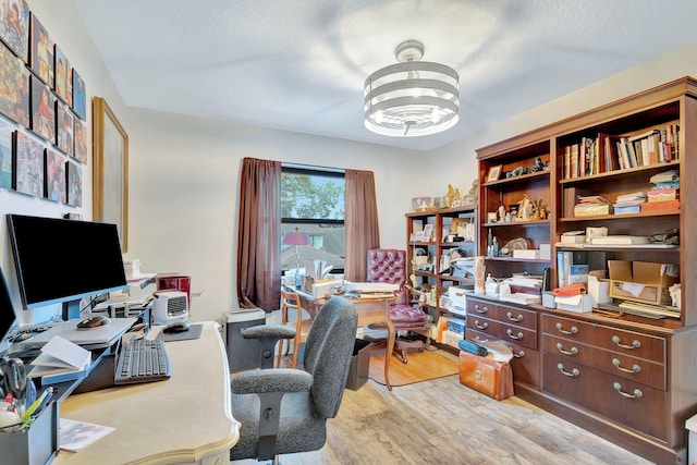 office area featuring a textured ceiling and light hardwood / wood-style flooring