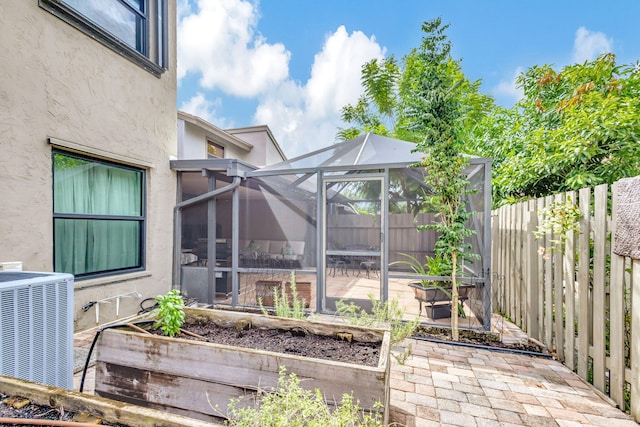 view of patio / terrace with a lanai and central air condition unit