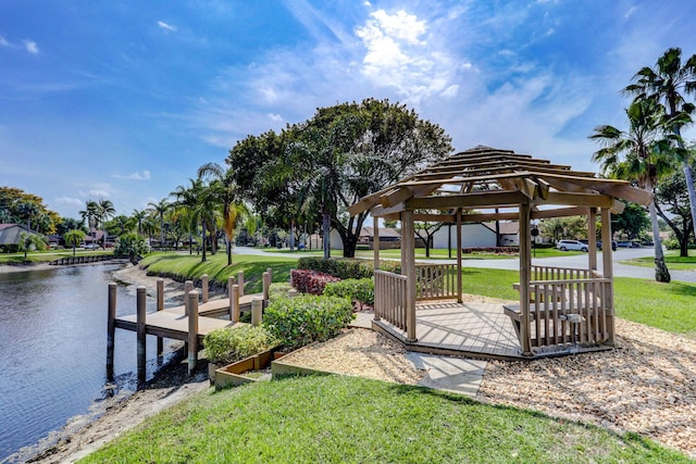 view of dock with a gazebo, a water view, and a yard