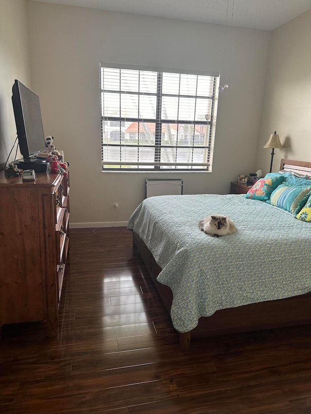 bedroom with dark hardwood / wood-style flooring