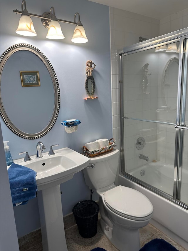 bathroom with bath / shower combo with glass door and toilet