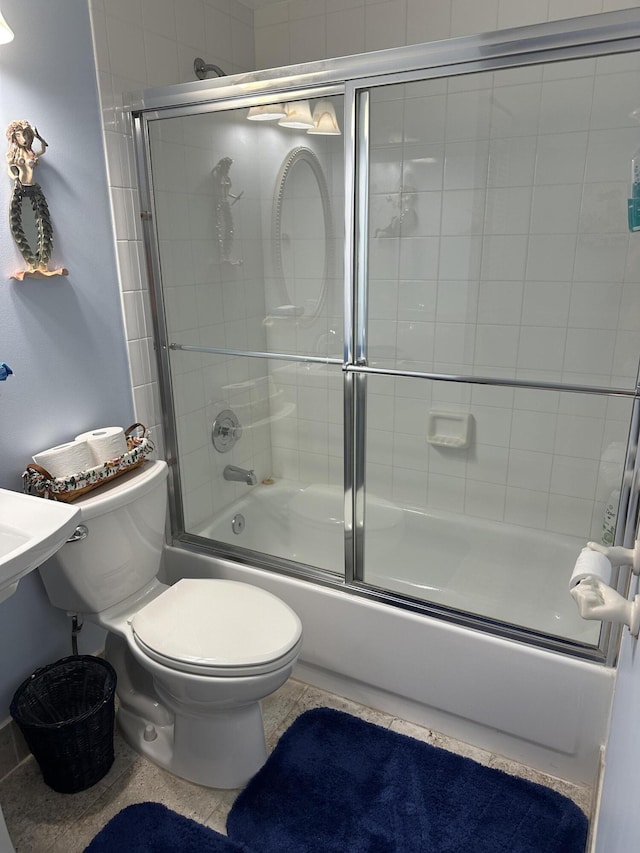 bathroom with bath / shower combo with glass door and toilet