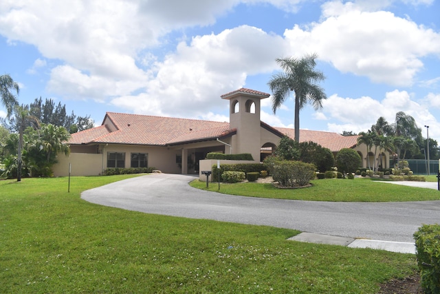 exterior space with a tiled roof, stucco siding, and a front lawn