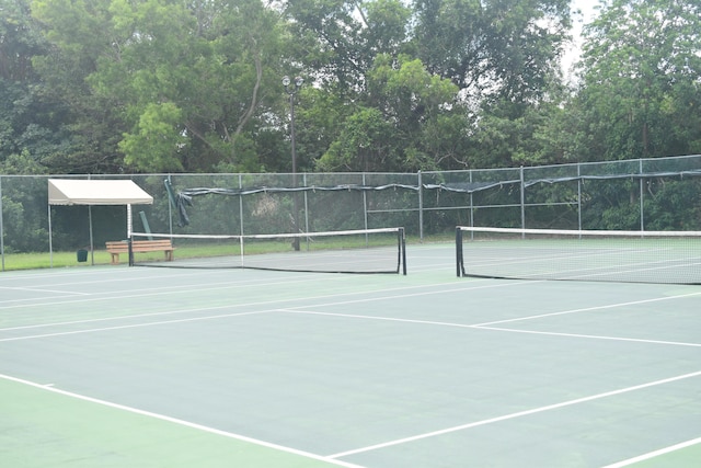 view of tennis court featuring fence