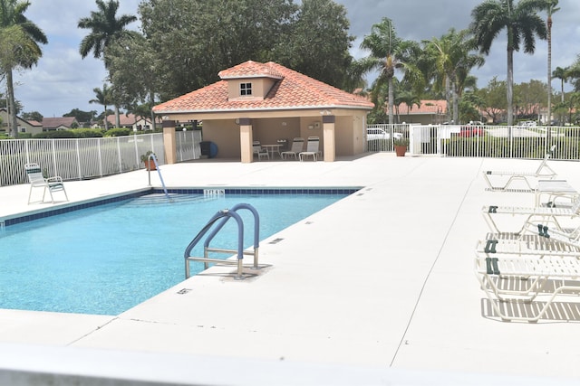 pool with a patio and fence