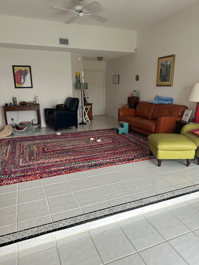 living room with a textured ceiling and ceiling fan