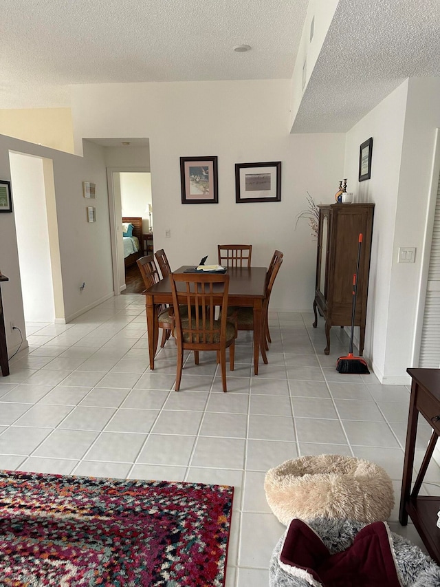 tiled dining space with a textured ceiling