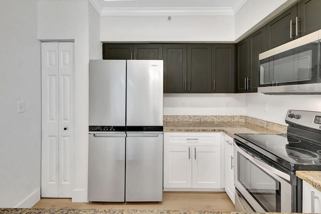 kitchen with appliances with stainless steel finishes, crown molding, white cabinetry, and light wood-type flooring