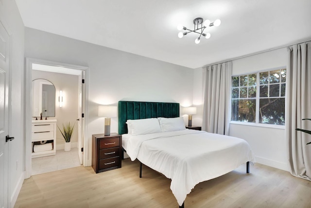 bedroom with an inviting chandelier and light hardwood / wood-style flooring