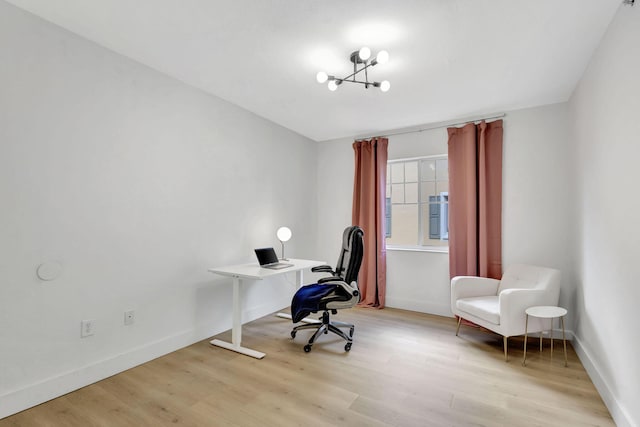 home office with a notable chandelier and light hardwood / wood-style floors