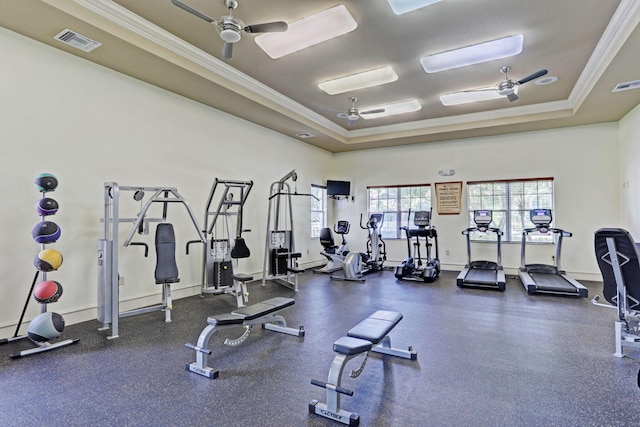 workout area with ceiling fan, a raised ceiling, and ornamental molding